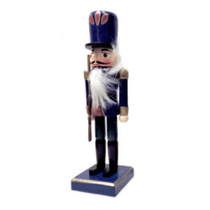 Christmas nutcracker in navy blue uniform with gold lining and red and green uniform on a festive background.